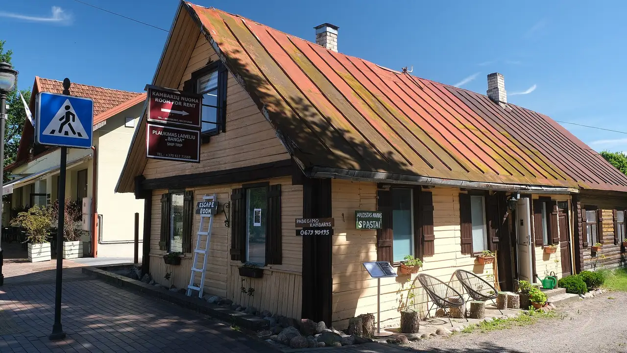 Medinis geltonas namas su oranžiniu stogu Birštone, priekyje – grindinio gatvė