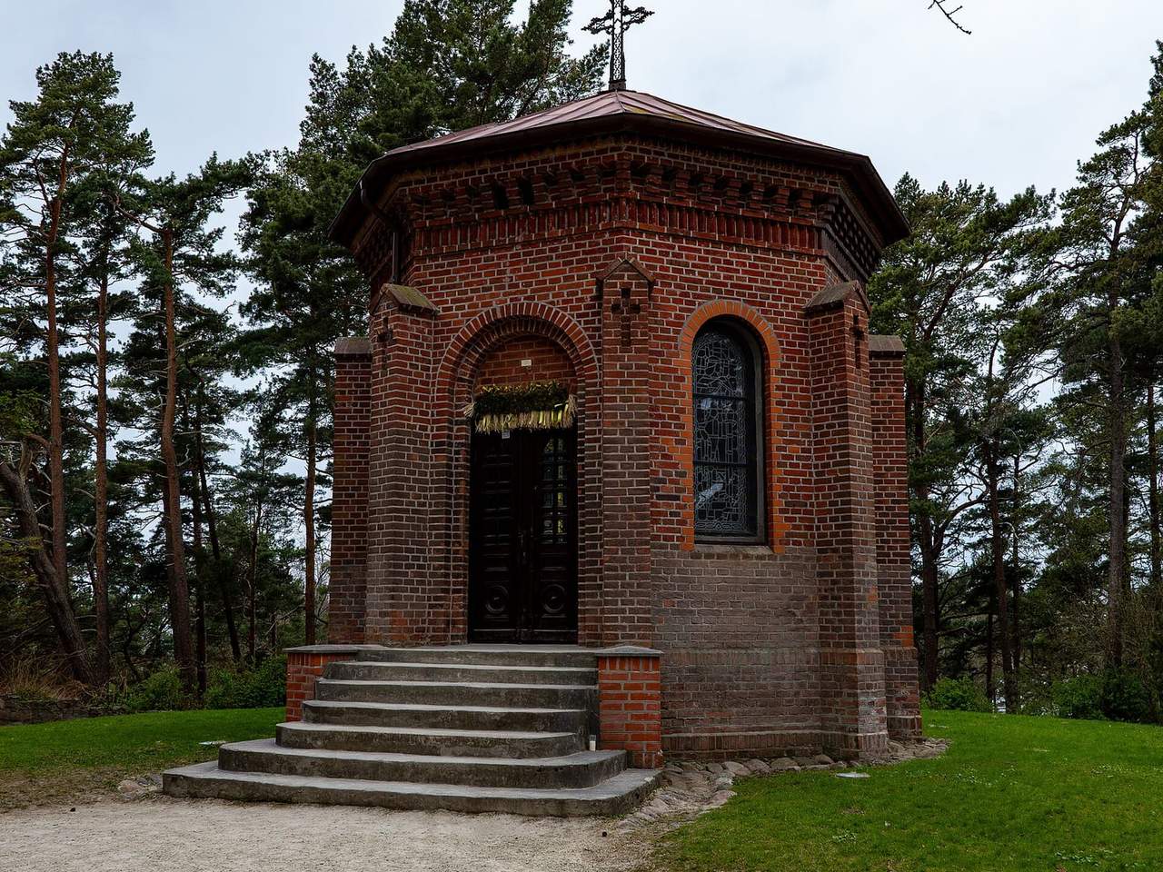 Raudonų plytų šv. Jurgio koplyčia ant Birutės kalno tarp pušų, priekyje laiptai