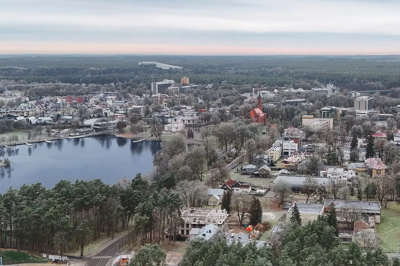 Druskininkų ežeras ir miesto stogai su raudonos plytos bažnyčia rudens rytą, iš oro