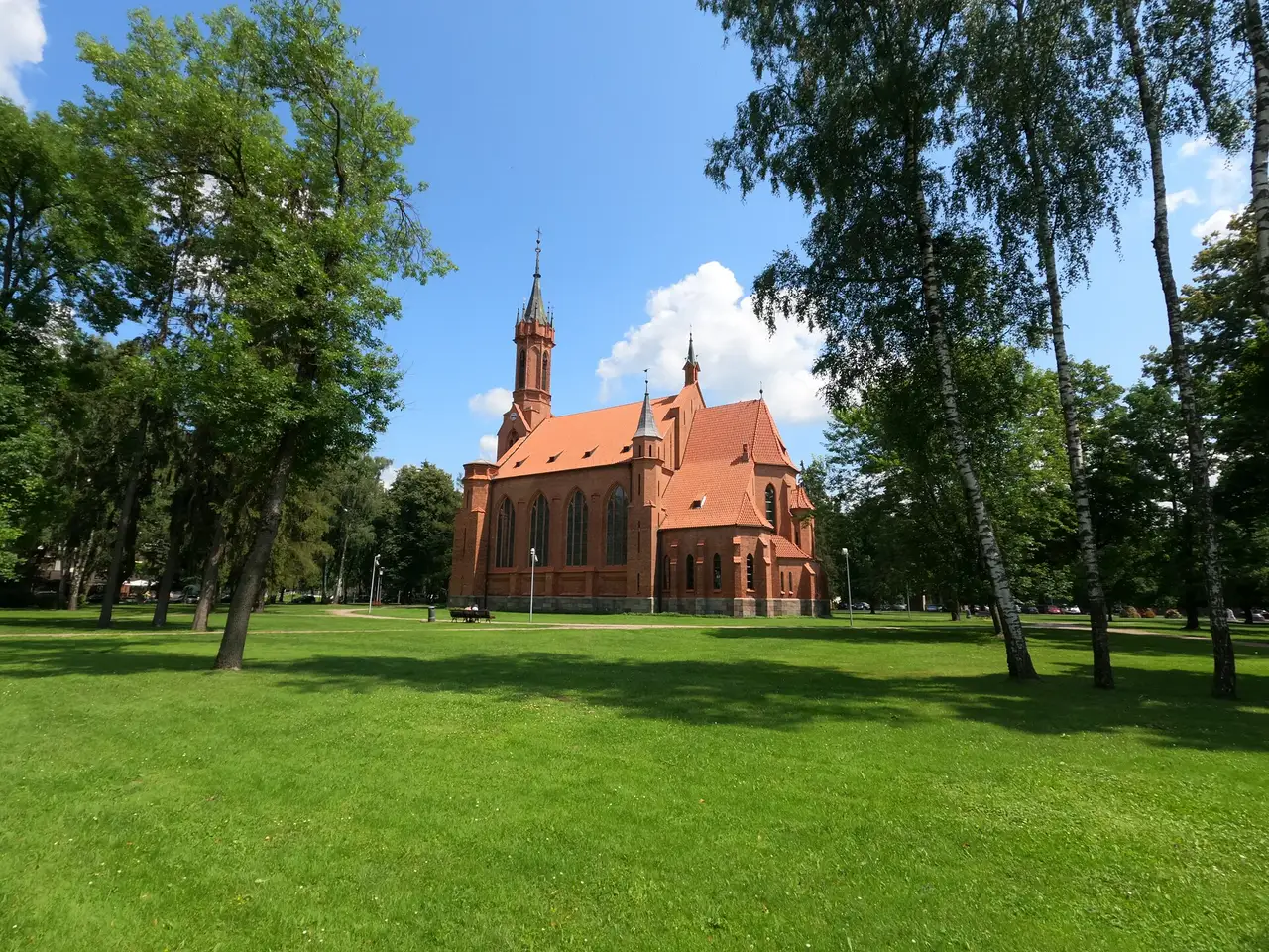 Raudonų plytų neogotikinė Druskininkų Švč. Mergelės Marijos Škaplierinės bažnyčia parke tarp medžių
