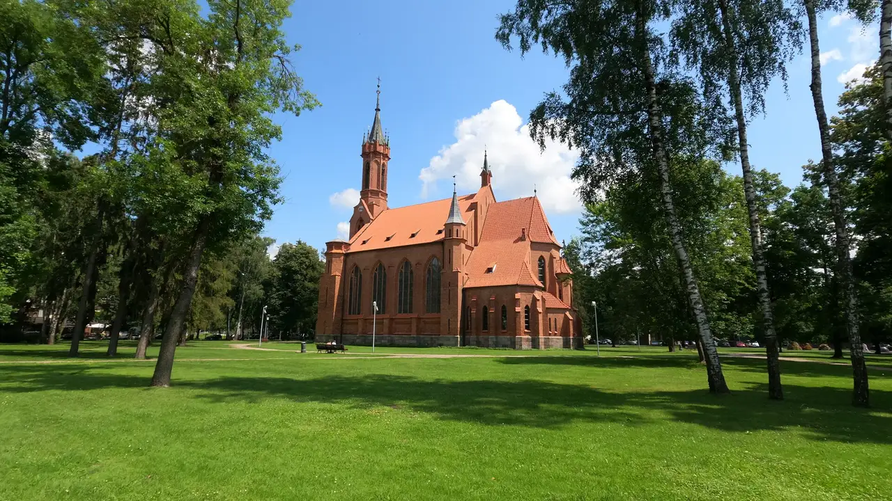 Raudonų plytų neogotikinė Druskininkų Švč. Mergelės Marijos Škaplierinės bažnyčia parke tarp medžių