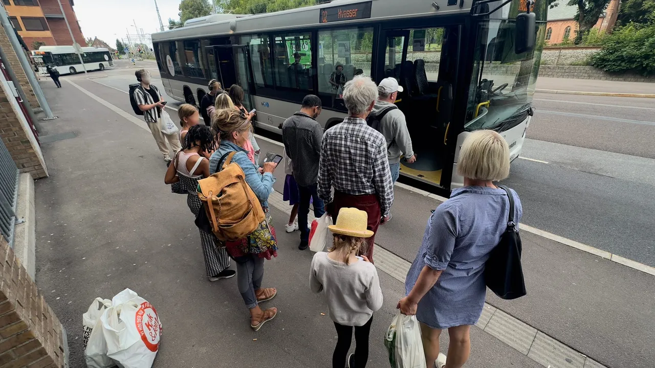Keleiviai stotelėje prieš lipdami į autobusą tikrina bilietus savo išmaniuosiuose telefonuose