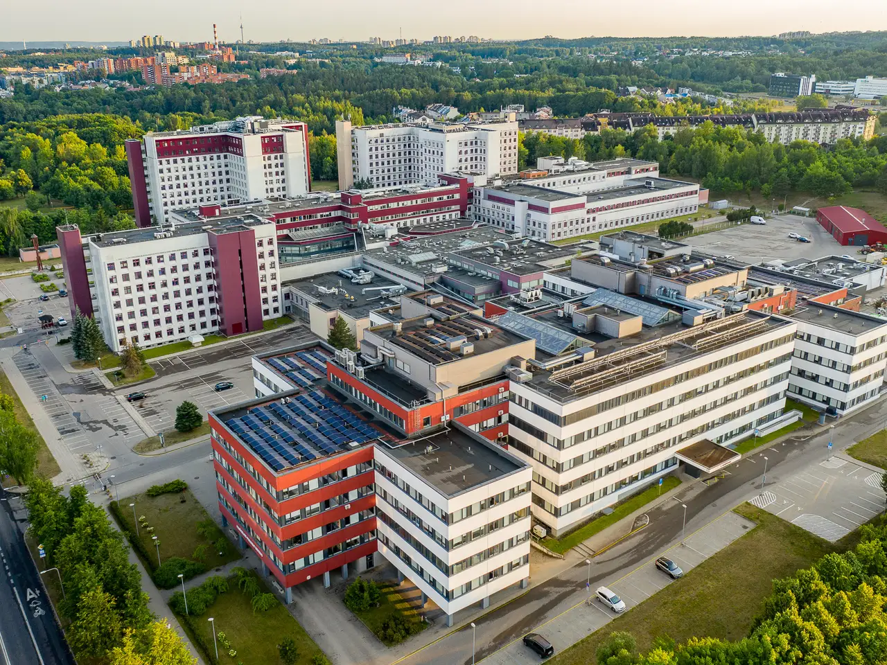 Santariškių klinikų pastatai Vilniuje iš paukščio skrydžio, tarp medžių ir gyvenamųjų kvartalų