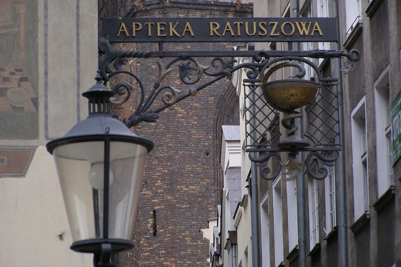 Kaltinė geležinė vaistinės iškaba „Apteka Ratuszowa“ Gdansko senamiestyje