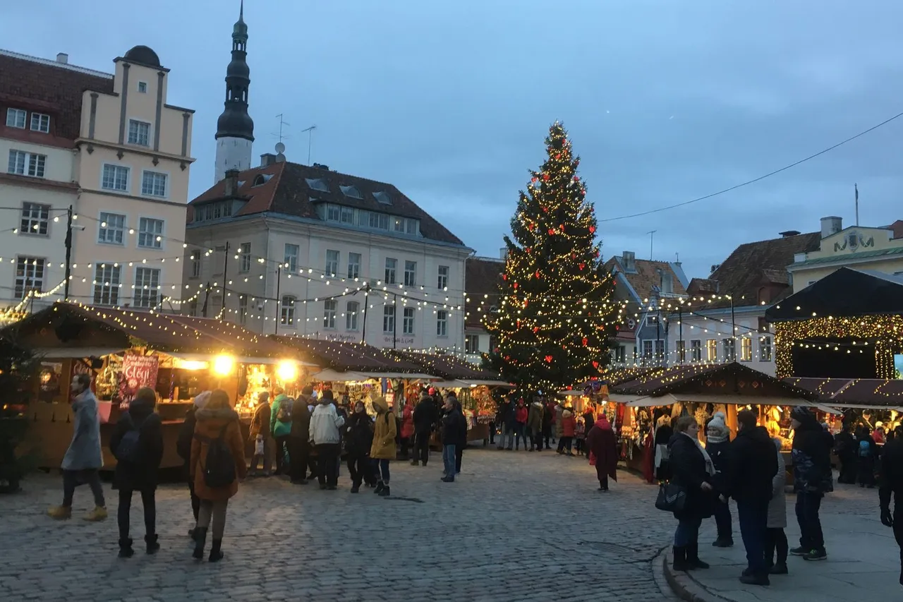 Apšviesti Talino Kalėdų turgaus namukai ir eglė Rotušės aikštėje prieblandoje