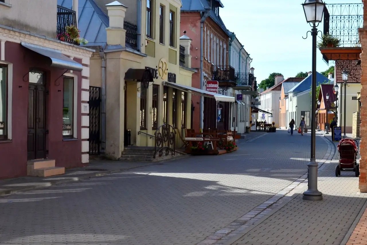 Pėsčiųjų gatvė Kėdainių senamiestyje su spalvingais namais ir gatvės žibintu
