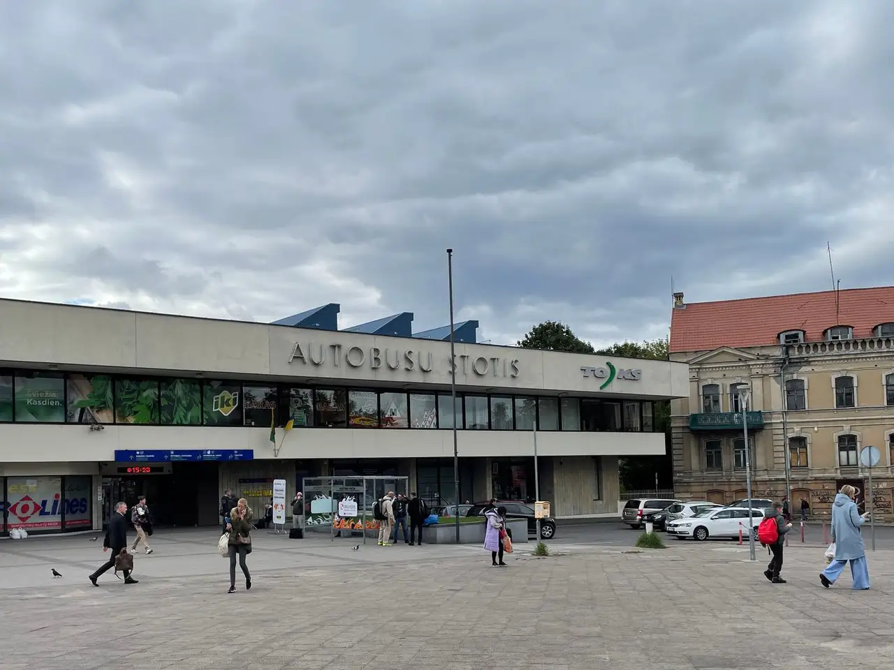 Vilniaus autobusų stoties pagrindinis įėjimas ir aikštė su skubančiais keliautojais