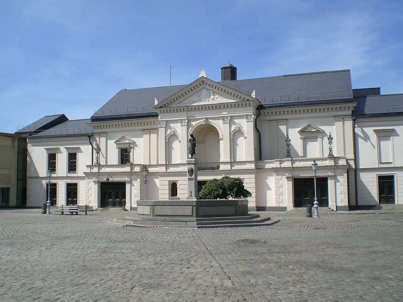 Klaipėdos dramos teatro pastatas, priekyje grindinio aikštė ir fontanas su skulptūra