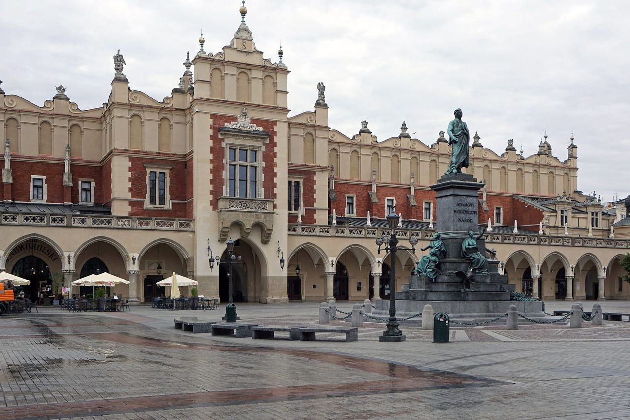 Renesansinė Sukiennice prekybos salė su arkomis Krokuvos Rinkos aikštėje, priekyje paminklas