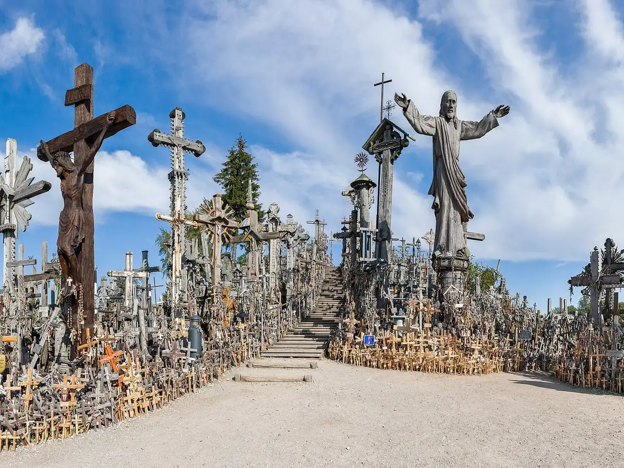 Daugybė kryžių ir Kristaus skulptūra ant Kryžių kalno, priekyje smėlio takas