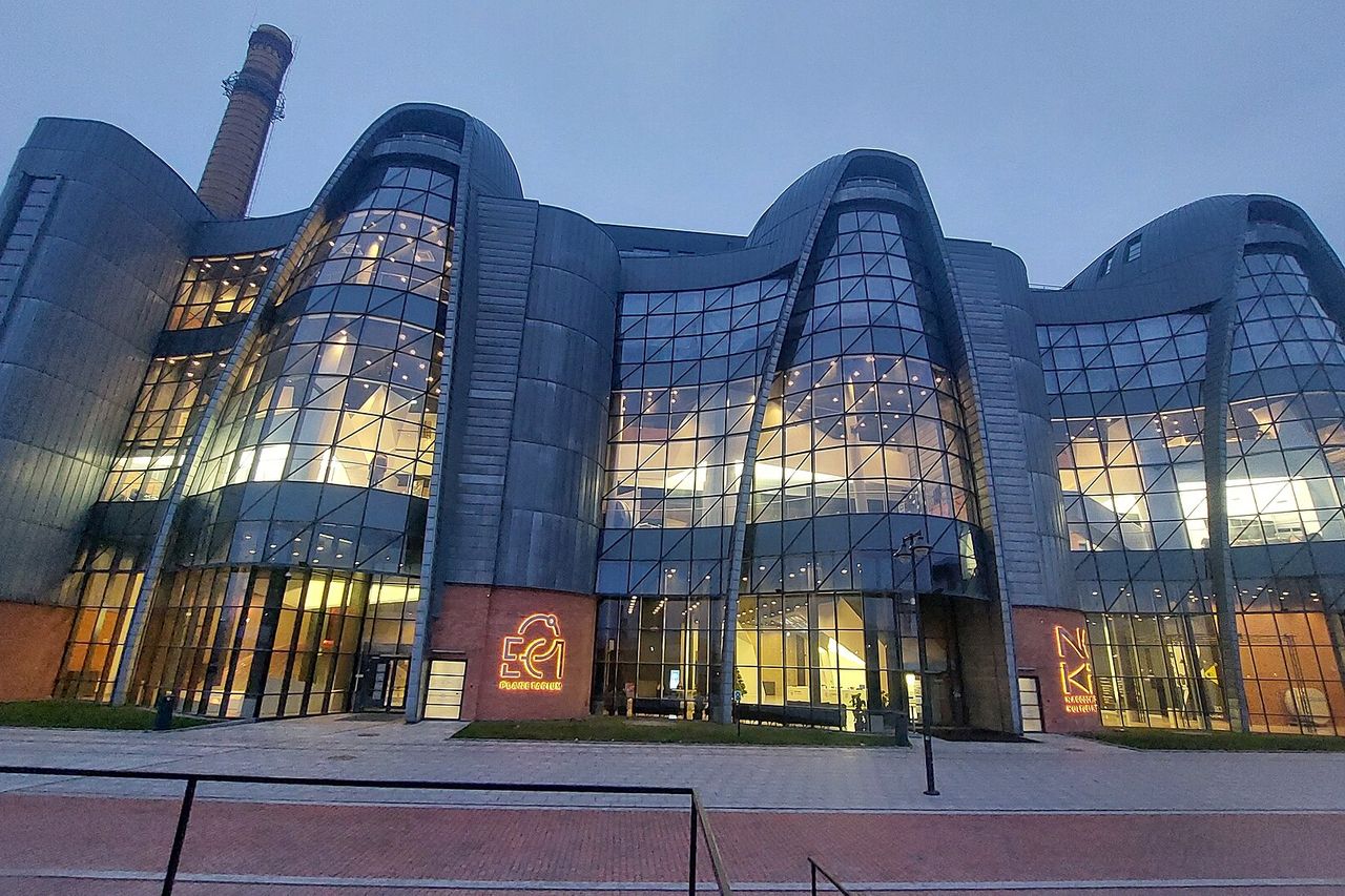 Vakaro prieblandoje švyti stiklinis EC1 planetariumo ir mokslo centro pastatas su senu fabriko kaminu