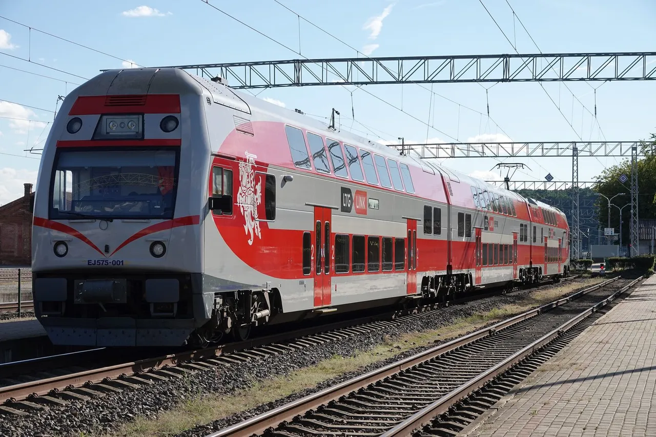 Raudonai baltas dviaukštis „LTG Link“ traukinys atvyksta į peroną saulėtą dieną