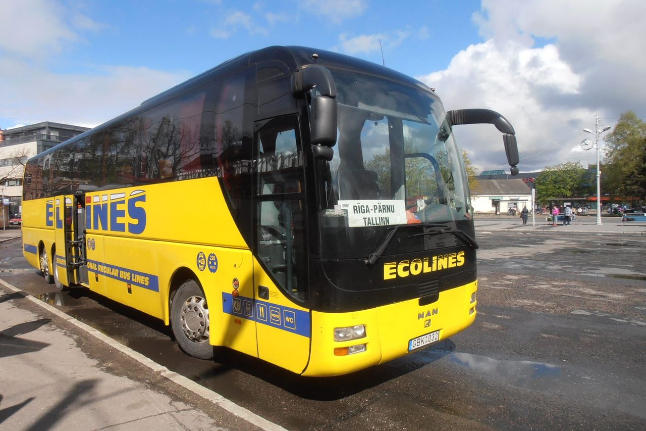 Geltonas tolimojo susisiekimo autobusas Pernu autobusų stoties aikštėje saulėtą dieną