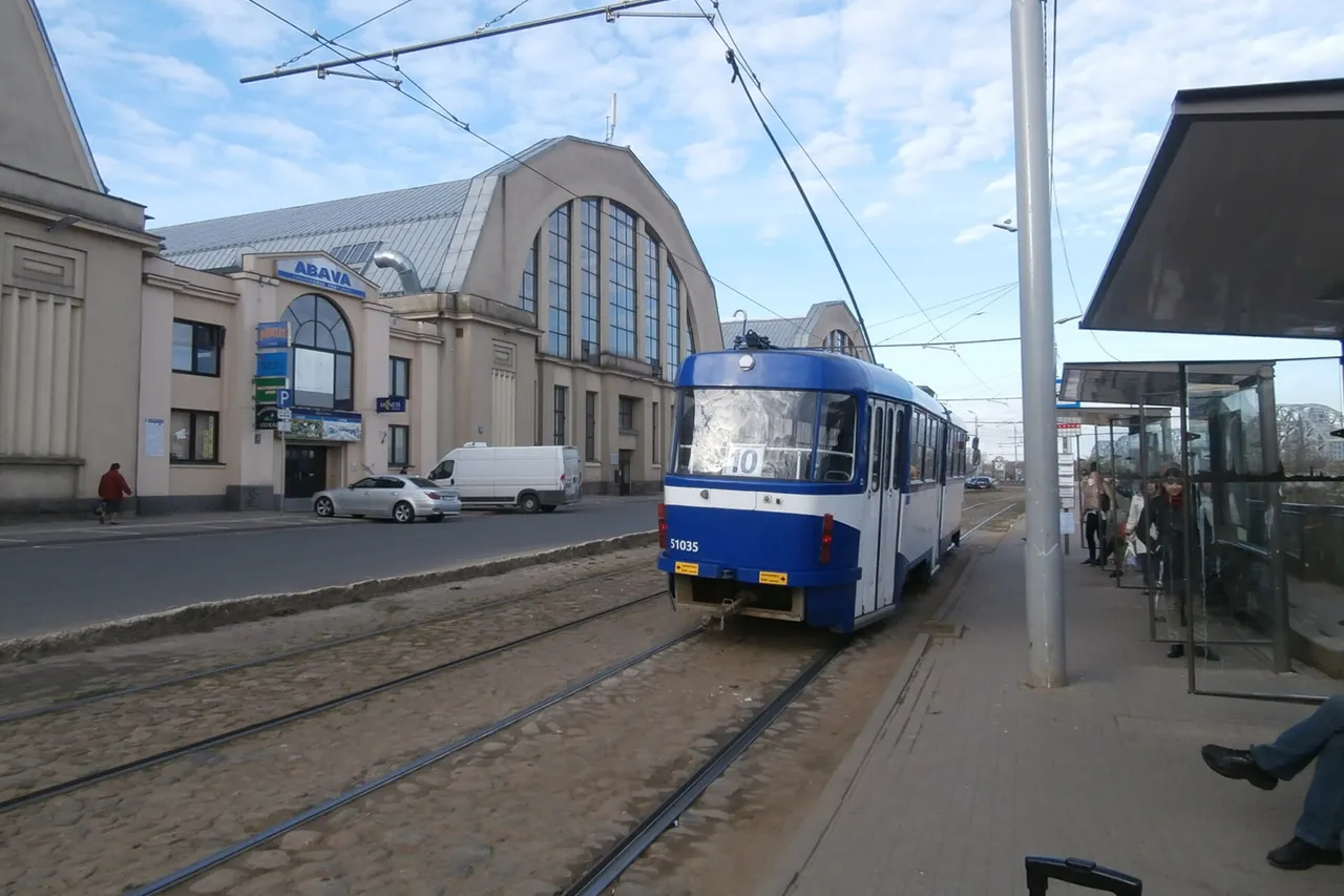 Mėlynas Rygos tramvajus prie Centrinės turgavietės paviljonų ir tramvajaus stotelės