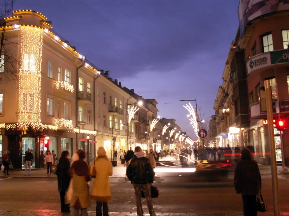 Šiaulių Vilniaus gatvė vakare su šventiniais šviesos vėrinais ir pėsčiaisiais