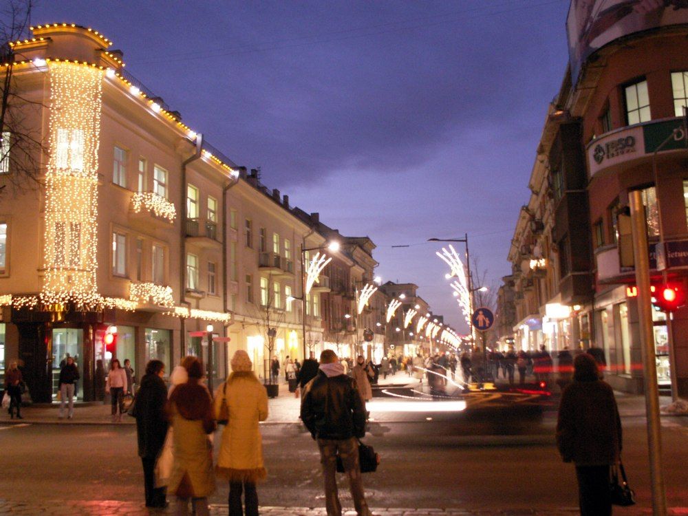 Šiaulių Vilniaus gatvė vakare su šventiniais šviesos vėrinais ir pėsčiaisiais