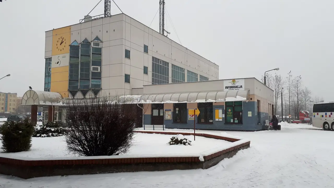 Žiemą apsnigtas Suvalkų autobusų stoties pastatas su laikrodžiu ir informacijos paviljonu