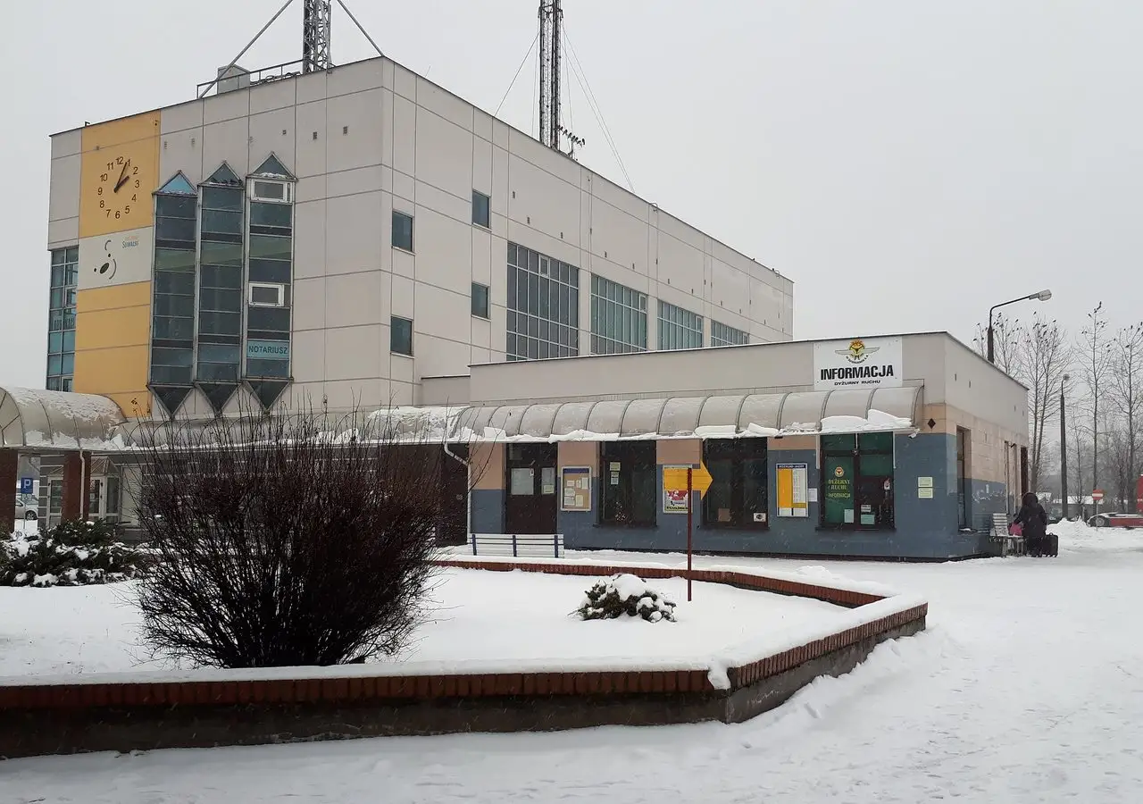 Žiemą apsnigtas Suvalkų autobusų stoties pastatas su laikrodžiu ir informacijos paviljonu