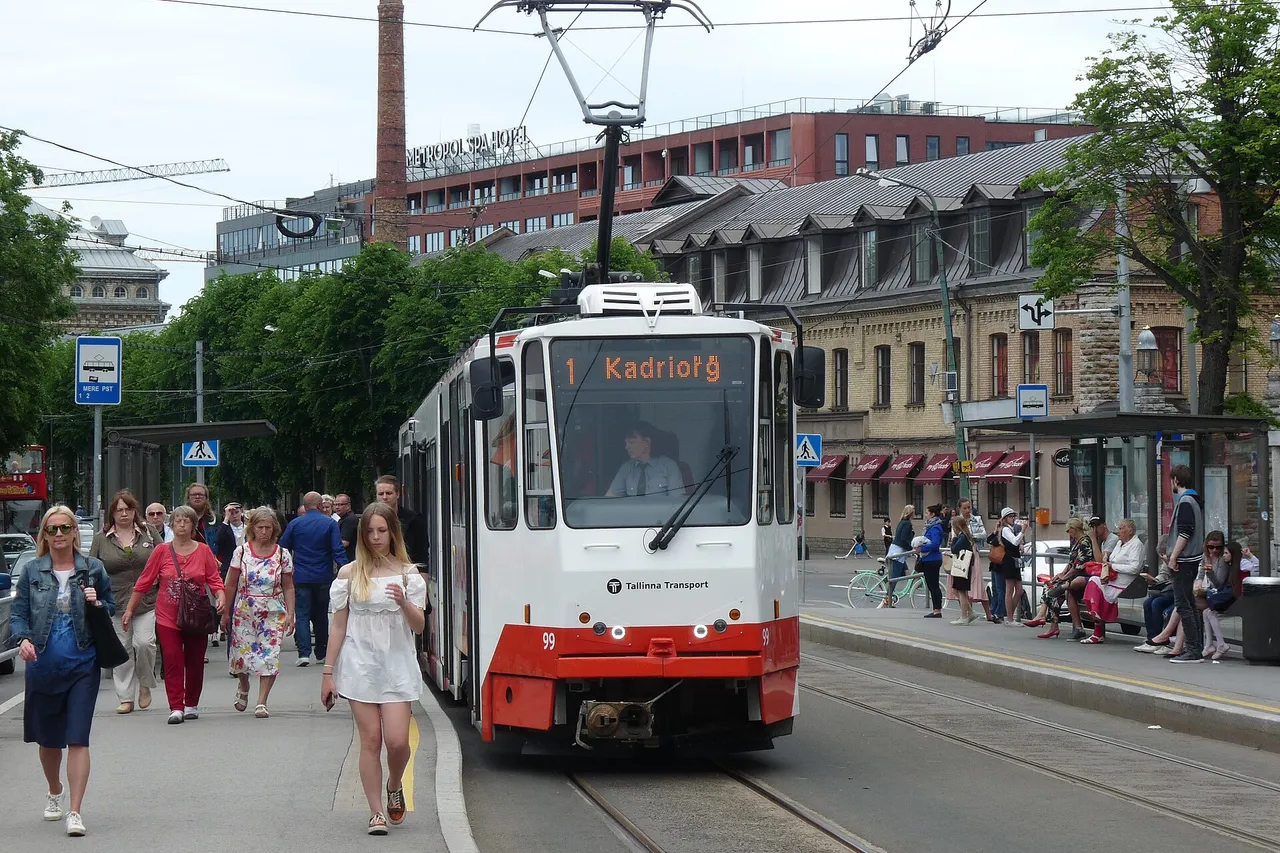 Baltai raudonas Talino tramvajus Nr. 1 sustoja prie Mere pst. stotelės tarp keleivių