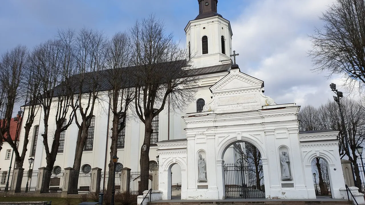 Balta Telšių Šv. Antano Paduviečio katedra su šventoriaus vartais ir plikais medžiais priekyje