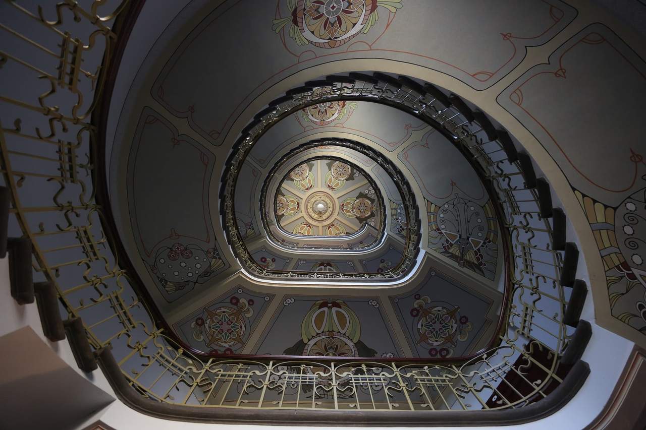 Art Nouveau muziejaus laiptinė Alberto gatvėje 12 Rygoje: išlenkti turėklai ir dažytos lubos