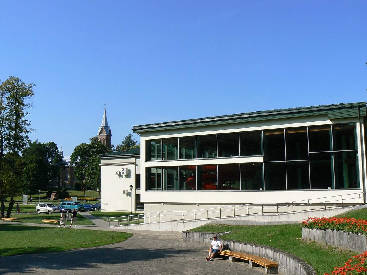 Stikliniais langais papuoštas „Tulpės“ sanatorijos korpusas Birštono parke saulėtą dieną