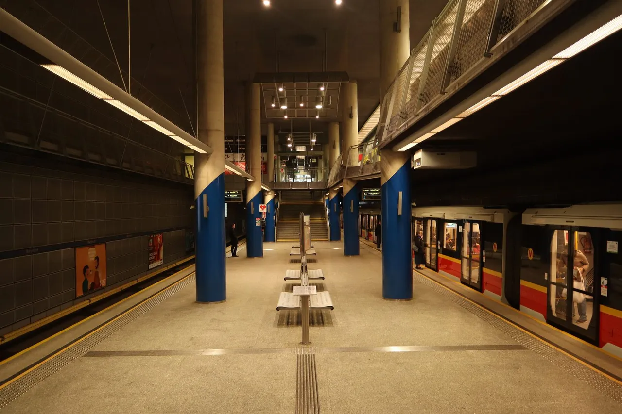 Varšuvos metro stoties Marymont peronas su mėlynais stulpais ir stovinčiu traukiniu