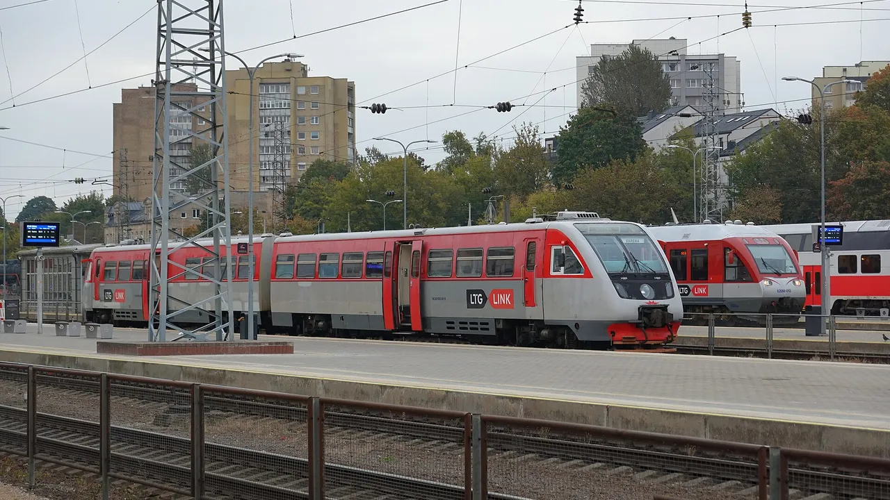 Raudonai pilkas „LTG Link“ dyzelinis traukinys su užrašu „Varėna“ Vilniaus stoties perone, šalia kitas traukinys