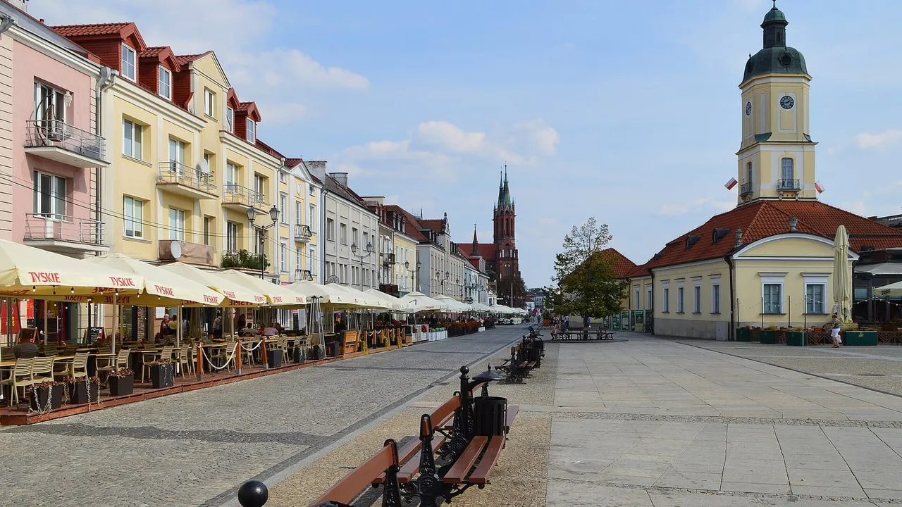 Balstogės Kościuškos aikštė su kavinėmis, ratušės bokštu ir raudonos katedros bokštais