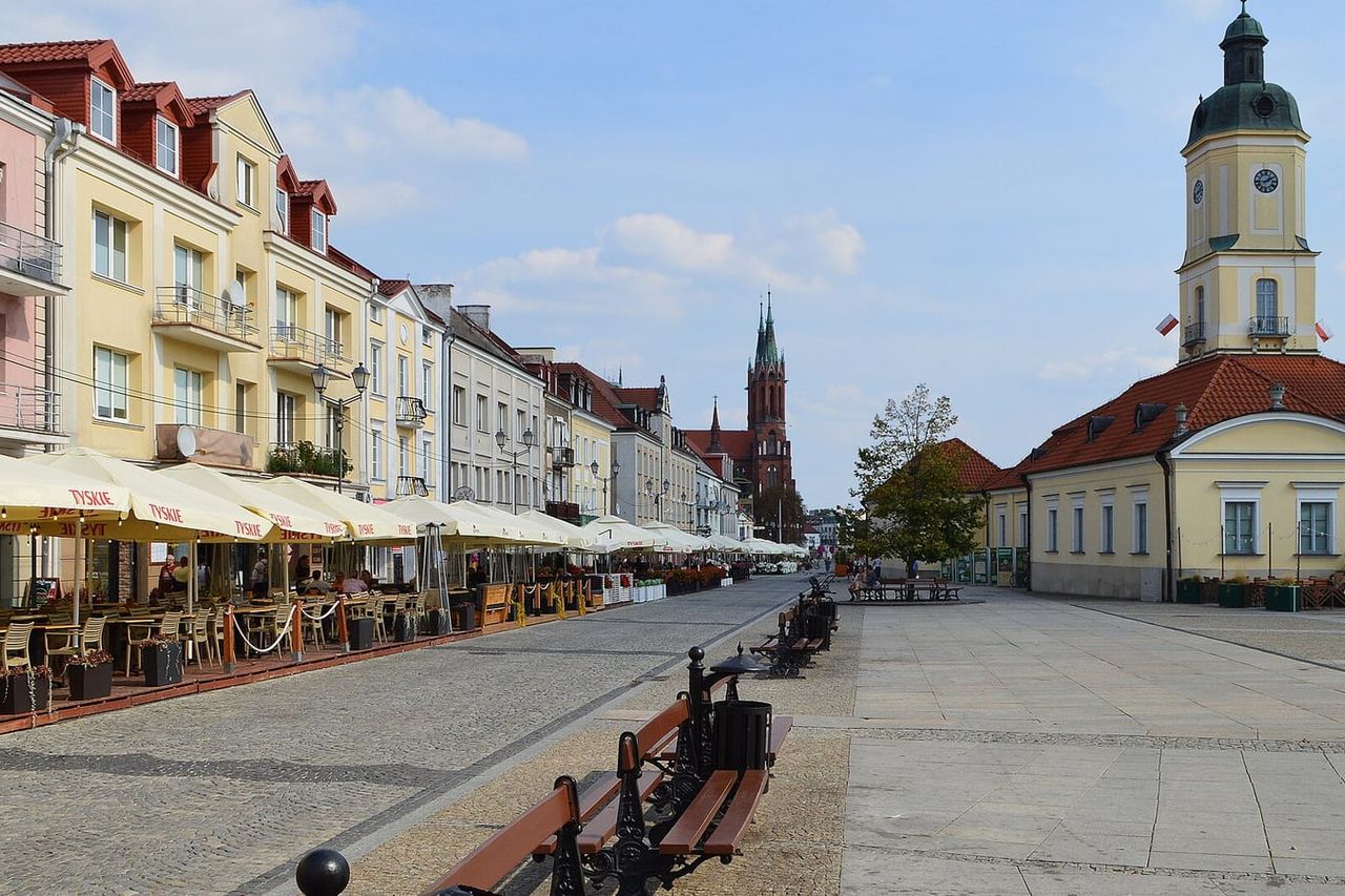 Balstogės Kościuškos aikštė su kavinėmis, ratušės bokštu ir raudonos katedros bokštais