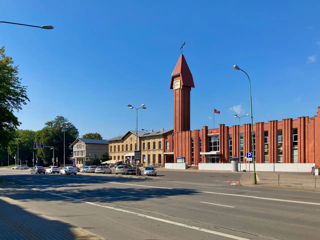 Klaipėdos geležinkelio stoties raudonų plytų pastatas su laikrodžio bokštu giedrą dieną