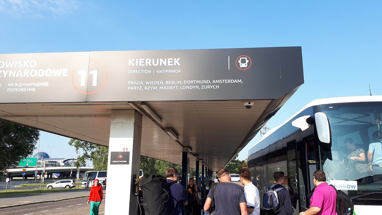 Keleiviai laukia autobuso po stoginės nuoroda Varšuvos Zachodnia autobusų stotyje saulėtą rytą