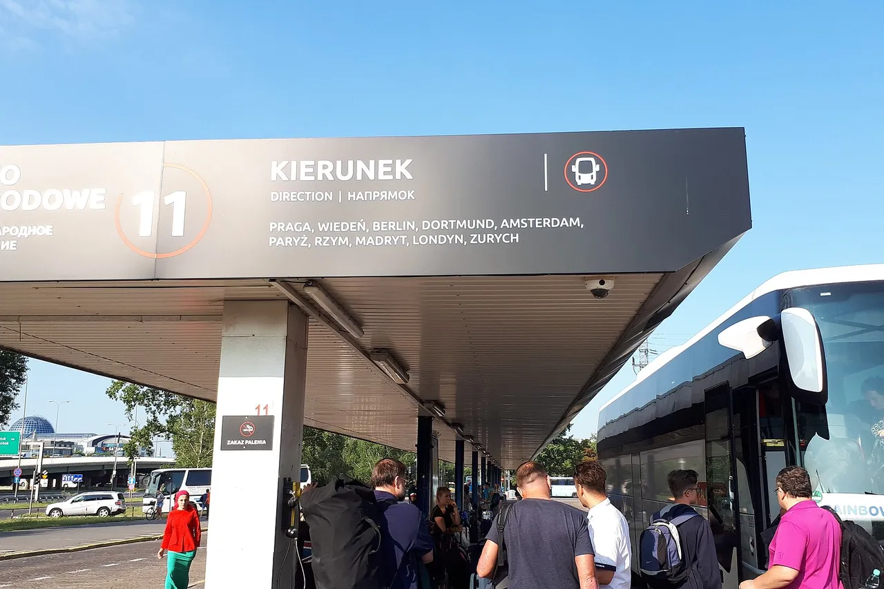 Keleiviai laukia autobuso po stoginės nuoroda Varšuvos Zachodnia autobusų stotyje saulėtą rytą